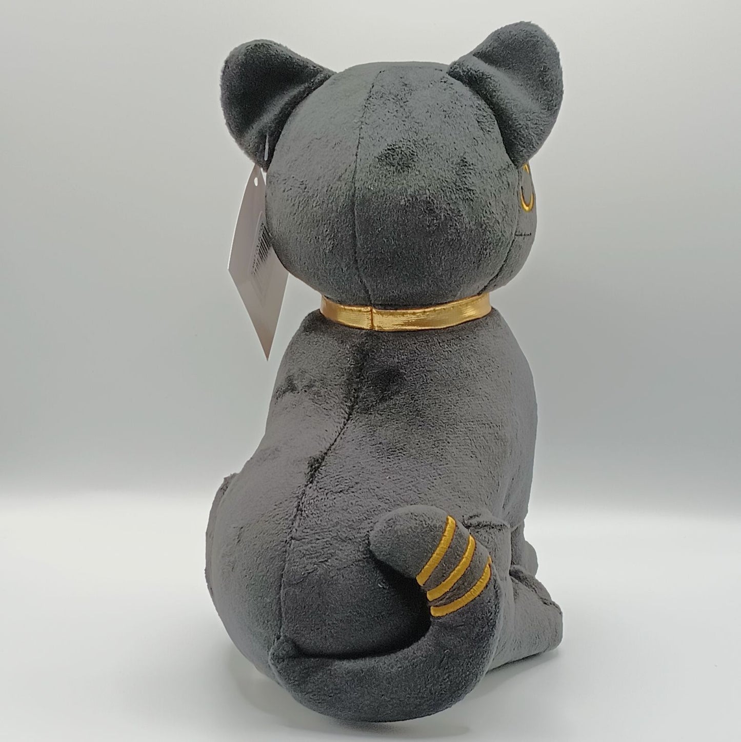 Gray plush cat toy with a gold collar on a white background