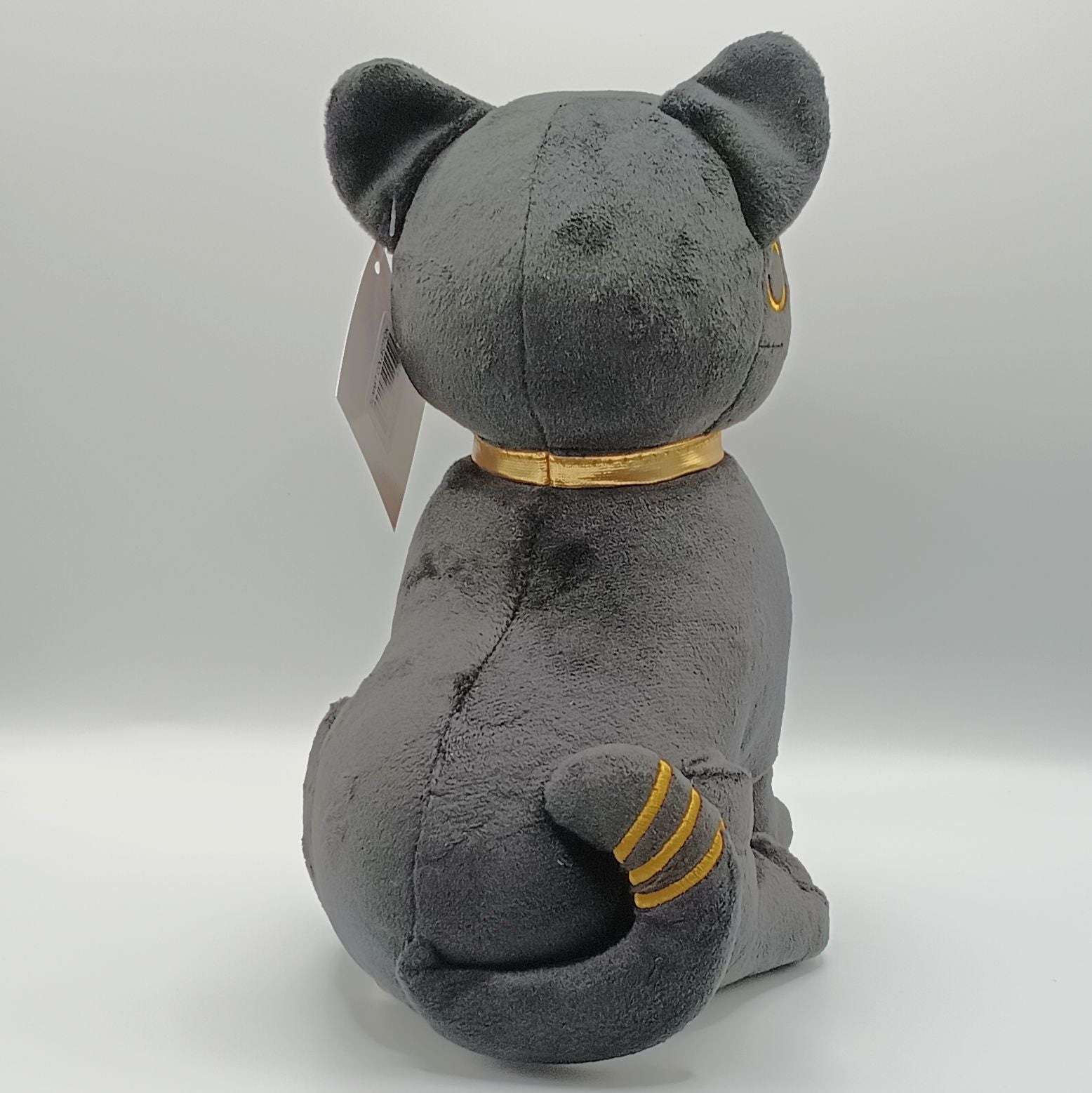 Gray plush cat toy with a gold collar on a white background
